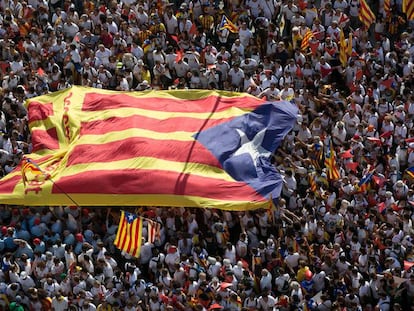Una inmensa bandera estelada pasa entre las manos de los participantes en una celebración de la Diada.