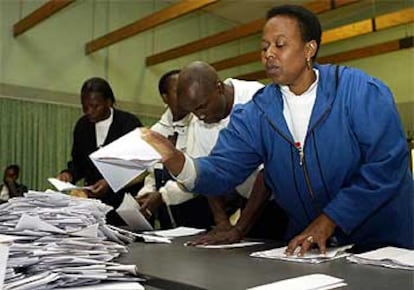 Varios miembros de una mesa electoral inician el recuento de las papeletas en un colegio de Johanesburgo.