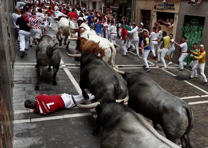 Un mozo cae ante los toros en la calle de La Estafeta de Pamplona.