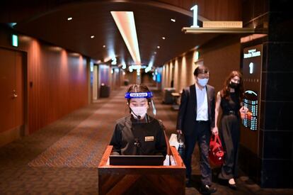 Una empleada con medidas de protección contra el coronavirus durante la reapertura de los cines en Tokio (Japón).