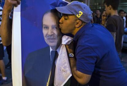 Un seguidor de Buteflika besa un cartel del presidente tras el triunfo.
