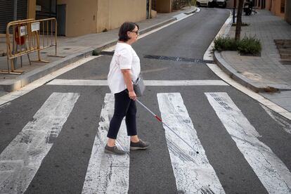 La concejal del distrito de Horta-Guinardó de Barcelona, Rosa Alarcón, que sufre el Síndrome de Meige, cruza una calle en el barrio de Sant Genís. 