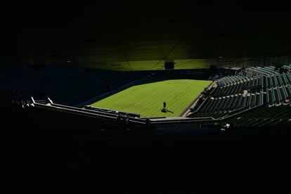 Un jardinero prepara la hierba de la pista central durante la segunda jornada del campeonato de Wimbledon (Reino Unido). El español Rafael Nadal, número diez del mundo, selló su pase a la segunda ronda del torneo de Wimbledon con un contundente triunfo sobre el brasileño Thomaz Bellucci (6-4, 6-2 y 6-4) en poco más de dos horas.