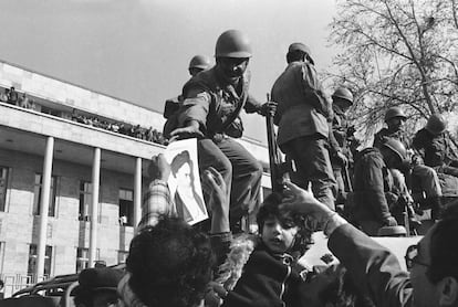 Los manifestantes entregan fotos de Jomeini y flores a los soldados frente a un edificio sin identificar en el centro de Teherán. La foto se tomó a mediados de enero de 1979. Aunque muchas de las manifestaciones se reprimieron con violencia, también hubo momentos de confraternización entre quienes protestaban contra el Sha y quienes tenían el deber de defender la monarquía.