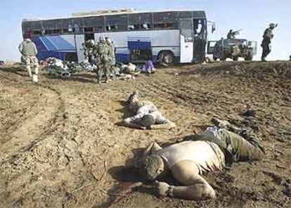 Cadáveres de soldados de la Guardia Republicana iraquí, junto a un autobús tiroteado previamente que está siendo registrado por los <b><i>marines,</b></i> en una importante carretera del centro de Irak.