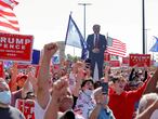 An image of U.S. President Donald Trump, who was diagnosed with the coronavirus disease (COVID-19), is held aloft amongst supporters as they gather at the New York Triumph Rally on Staten Island in New York City, U.S., October 3, 2020. REUTERS/Andrew Kelly     TPX IMAGES OF THE DAY