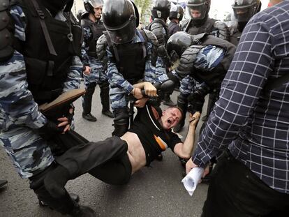 Membros da polícia prendem um dos participantes da manifestação opositora em Moscou.