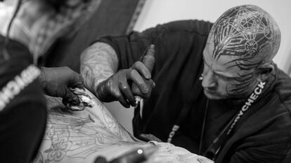 Un artista tatúa en la espalda a un hombre durante la Convención Internacional del Tatuaje en Berlín, en septiembre de 2022.