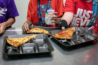 Second-grade students select their meals during lunch break in the cafeteria at an elementary school in Scottsdale, Ariz., Dec. 12, 2022.