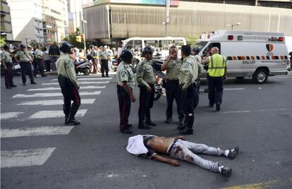 La policía rodea el cuerpo de un hombre asesinado en Caracas, en 2012