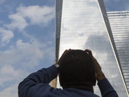 Un hombre observa desde abajo a los dos limpiacristales colgados en el World Trade Center