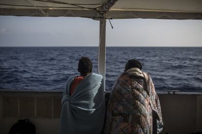 Dos migrantes hablan y observan el mar desde el Open Arms, el 2 de julio de 2018.