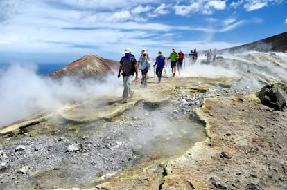 Un grupo de senderistas camina en dirección al Gran Cráter de la Fossa, entre fumarolas de azufre, en la isla italiana de Vulcano.