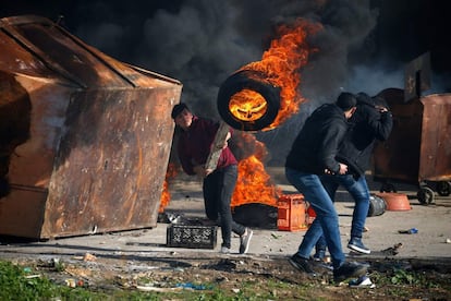 El atentado en el cruce de Asaf es uno de los más graves en la escalada de violencia registrada en la última semana en Cisjordania. En la imagen, un hombre palestino utiliza un palo de madera para lanzar un neumático en llamas.