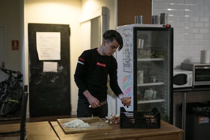 En la imagen, uno de los jóvenes extutelados prepara la cena en la cocina de un hostal.