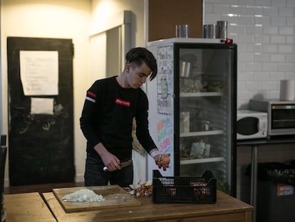 En la imagen, uno de los jóvenes extutelados prepara la cena en la cocina de un hostal.