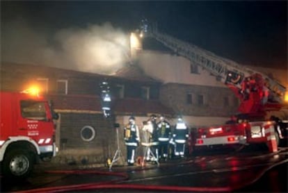 Los bomberos tratan de sofocar el incendio ocurrido en el Club Alpino Español, situado en el puerto de Navacerrada.