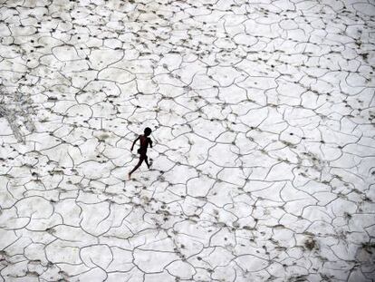 Un ni&ntilde;o salta entre las falsas baldosas del cauce seco de un r&iacute;o en Allahabad (India)