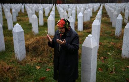 Hatidza Mehmedovic reza junto a las tumbas de sus dos hijos y su marido en el cementerio conmemorativo de Potocari, cerca de Srebrenica, el 14 de noviembre de 2017. El Potocari yacen sepultadas más de 6.000 de los 8.3000 víctimas del genocidio.