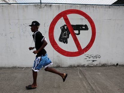 Un hombre corre frente a un graffiti en Guayaquil (Ecuador), el 12 de enero.