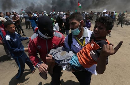 Um jovem ferido é levado durante os confrontos com as forças de segurança israelenses na fronteira entre Gaza e Israel.