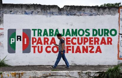 Un hombre camina ante un muro promocional del PRI en Xalapa (Veracruz).