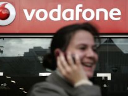 Usuaria del m&oacute;vil ante una tienda de Vodafone.