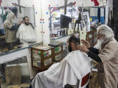 El peluquero don Manuel con un cliente.