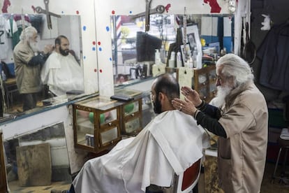 El peluquero don Manuel con un cliente.