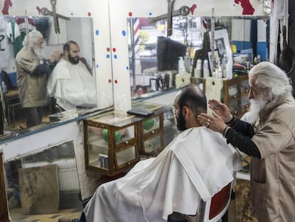 El peluquero don Manuel con un cliente.