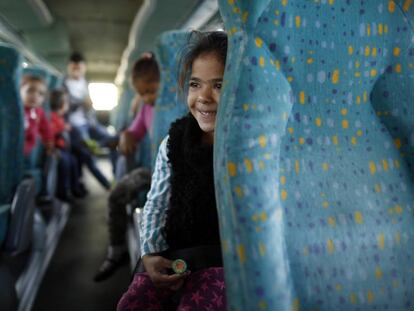 Ni&ntilde;os gitanos rumanos del poblado chabolista de El Gallinero, en Madrid, van al colegio en transporte escolar. 