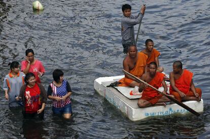 Monjes budistas intentan desplazarse con una balsa improvisada en las afueras Bangkok