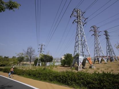 Una persona pasa cerca de varias torres eléctricas, en Madrid.