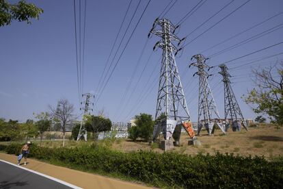 Una persona pasa cerca de varias torres eléctricas, en Madrid.