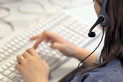 Una teleoperadora atiende la llamada de un consumidor en el teléfono de atención al cliente.