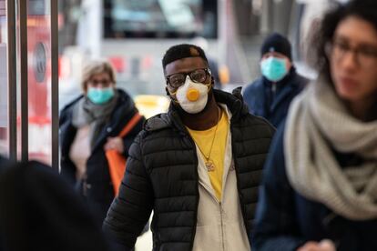 Pasajeros con mascarillas llegan a una estación de tren de Milán tras el anuncio del presidente Conte del aislamiento de 16 millones de personas en el norte del país por el coronavirus.