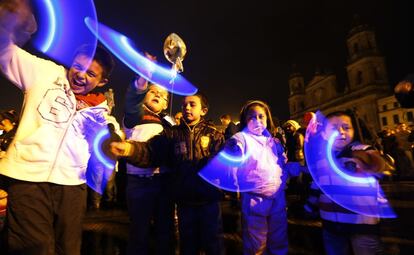 Unos niños juegan durante el encendido de luces navideñas en Bogotá (Colombia), 29 de noviembre 2013.