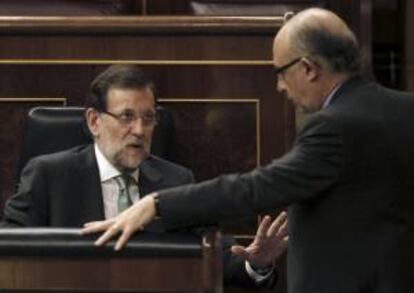 El presidente del Gobierno, Mariano Rajoy (i), conversa con el ministro de Hacienda, Cristóbal Montoro (d), hoy en el Congreso de los Diputados.