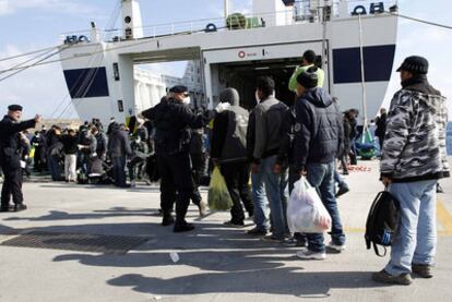 Un grupo de inmigrantes embarca en un transbordador en el puerto de Lampedusa.