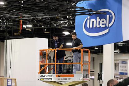 Dos operarios preparan en espacio de Intel en la feria de electrónica de consumo de Las Vegas, el CES, que comienza el 5 de enero.