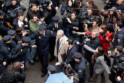 Agentes del Cuerpo Nacional de la Policía abren paso al juez Garzón entre los periodistas que le esperaban a las puertas del Supremo.