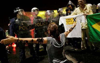 Una mujer se arrodilla frente a la policía que permanece a las afueras del Palácio do Planalto, sede del poder ejecutivo del Gobierno Federal brasileño.