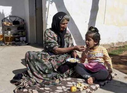 Una mujer kurda alimenta a su hija en la aldea de Beagova, cerca de la frontera turca, donde se encuentra desplazada por la guerra.