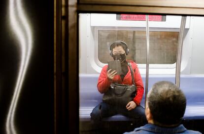 Un pasajero del metro de Nueva York usando mascarilla.