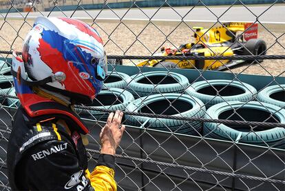 Petrov contempla su Renault desde la grada después de abandonarlo por un accidente sin daños
