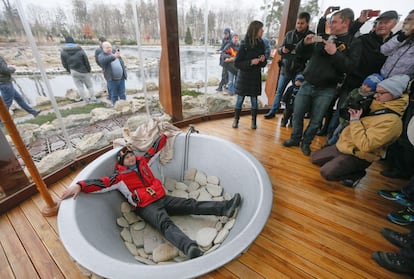 Un hombre posa sonriente dentro de la bañera que en su residencia de las afueras de Kiev tenía el presidente Yanukóvich, contemplado por un numeroso grupo de personas que entró en su casa de Kiev. El Parlamento acababa de destituir al Presidente.