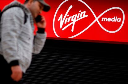 Un transeúnte  pasea frente a una tienda de Virgin Media cerrada por la covid-19 en Londres.