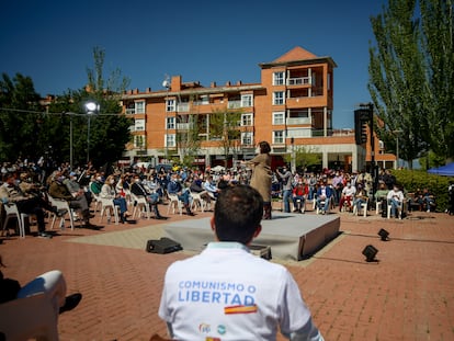 Un hombre acude a un acto electoral del PP con un polo donde se lee "comunismo o libertad" en Las Rozas, Madrid.