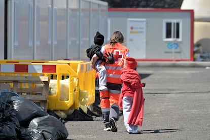 Una empleada de Salvamento Marítimo, con menores inmigrantes llegados a Canarias en un cayuco a El Hierro la semana pasada.