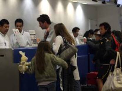 Unos turistas facturan su equipaje en el aeropuerto de Cancún. EFE/Archivo